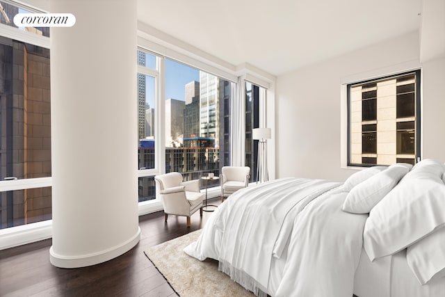 bedroom featuring a view of city and wood finished floors