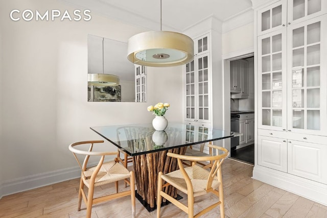 dining space featuring light hardwood / wood-style flooring and ornamental molding