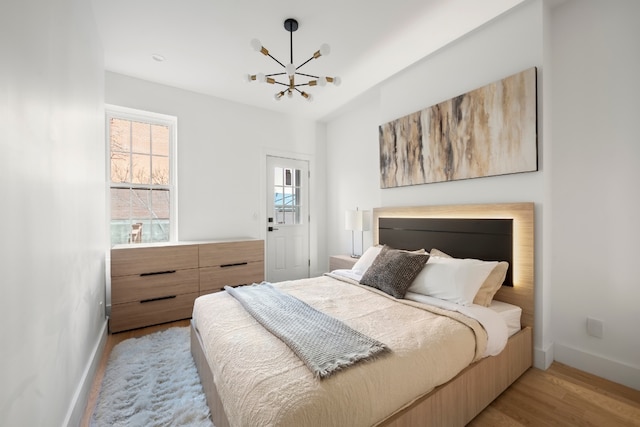 bedroom featuring a notable chandelier and light hardwood / wood-style flooring