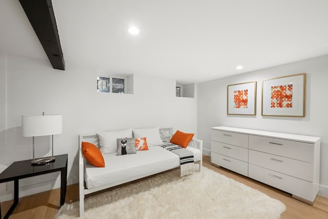 living area with beam ceiling and light wood-type flooring