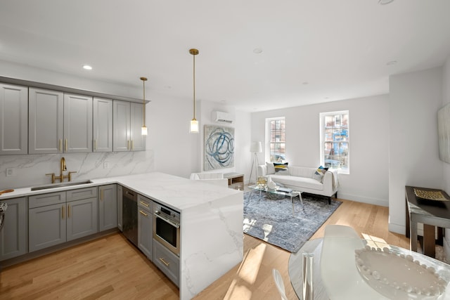 125 Beadel St, New York City, NY 11222 - kitchen featuring gray cabinetry, a sink, a peninsula, light wood-type flooring, and recessed lighting