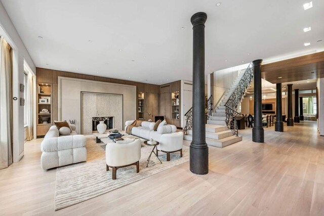 living room with light wood-type flooring and wood walls