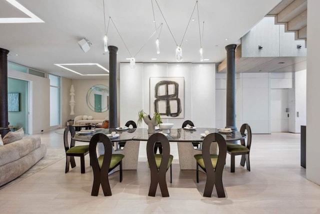 dining room featuring ornate columns and a wood stove