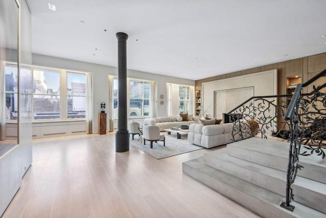 living room with ornate columns and light wood-type flooring