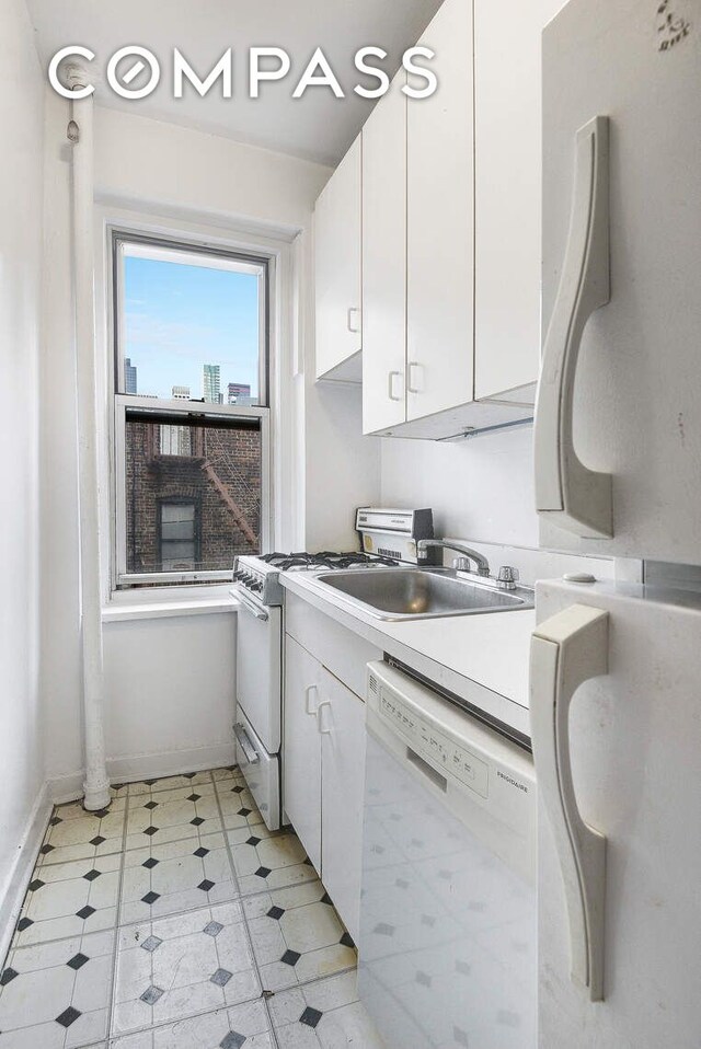 kitchen with white appliances, sink, and white cabinets