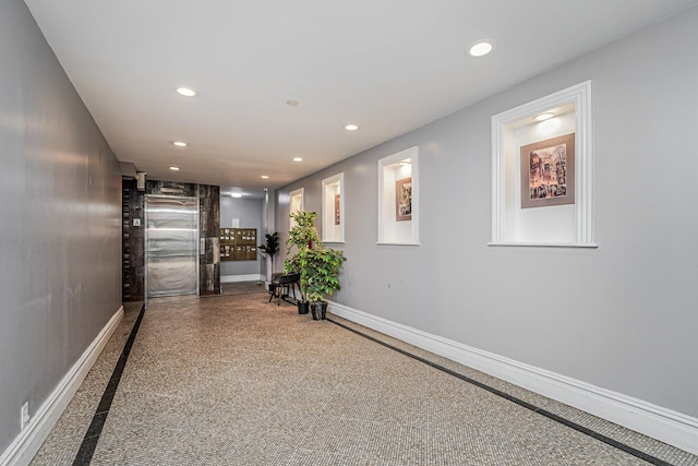 hallway with recessed lighting and baseboards