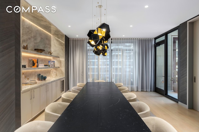 kitchen featuring light wood-style flooring, decorative light fixtures, floor to ceiling windows, white cabinetry, and recessed lighting