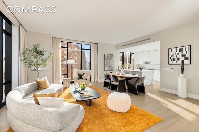 living room with light wood-type flooring and baseboards