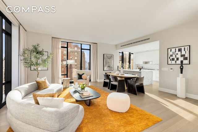 living area with baseboards and light wood-type flooring