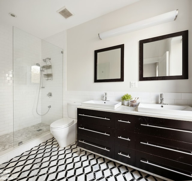 bathroom featuring visible vents, a sink, and walk in shower