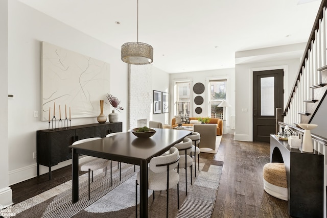 dining area with stairs, dark wood-type flooring, and baseboards