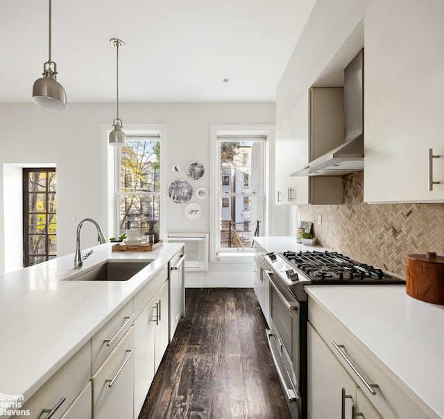 kitchen with dark wood-style floors, light countertops, decorative backsplash, appliances with stainless steel finishes, and a sink