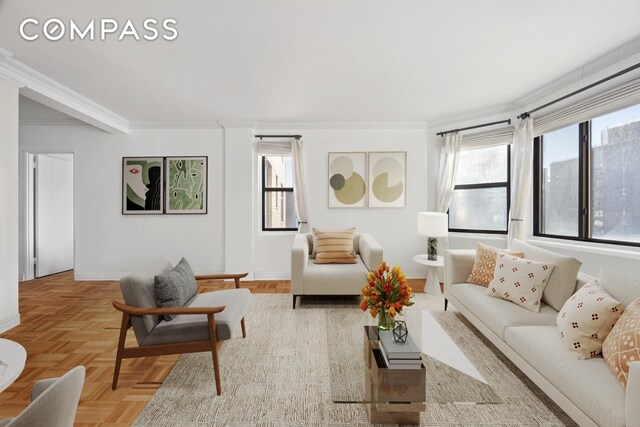 living room featuring light parquet flooring, ornamental molding, and plenty of natural light