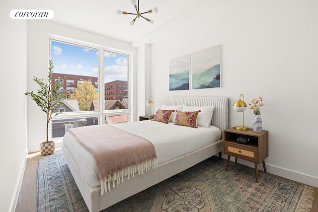 bedroom with hardwood / wood-style floors and a notable chandelier