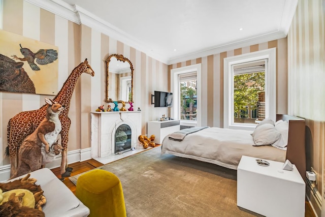 bedroom with a fireplace with flush hearth, wallpapered walls, crown molding, and baseboards