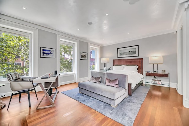 bedroom featuring baseboards, wood finished floors, and crown molding