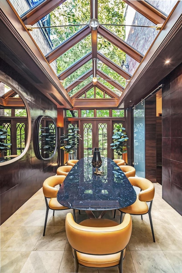 sunroom featuring lofted ceiling with skylight