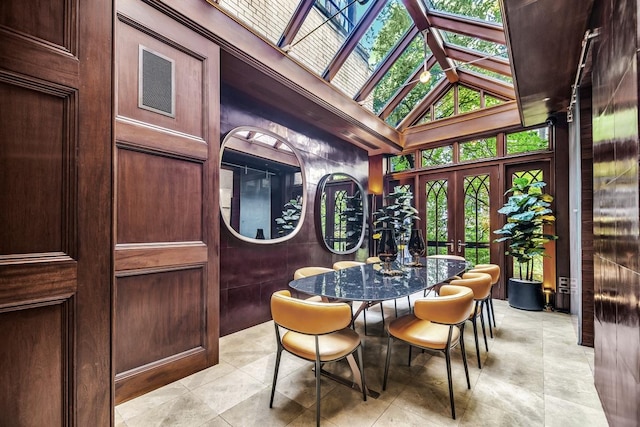 sunroom / solarium with lofted ceiling with skylight and french doors