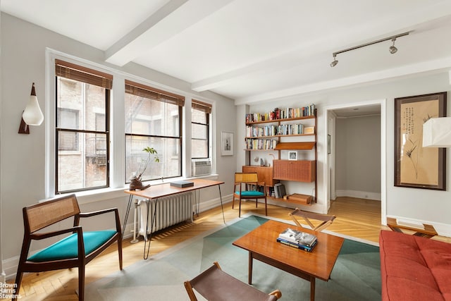 sitting room with baseboards, parquet floors, radiator, beamed ceiling, and track lighting