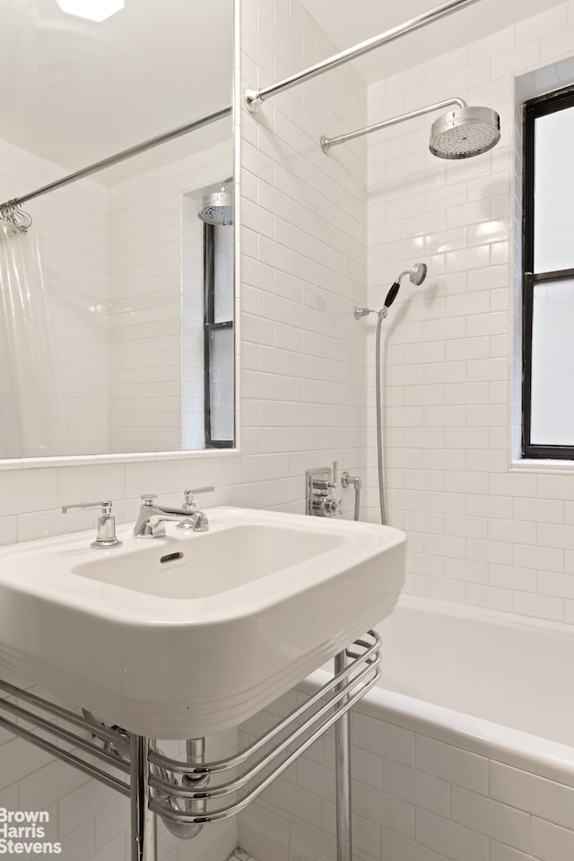 full bath featuring tiled shower / bath and tile walls