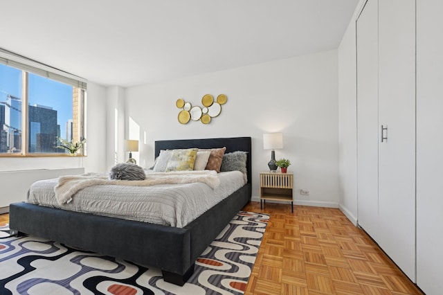 bedroom featuring a view of city and baseboards