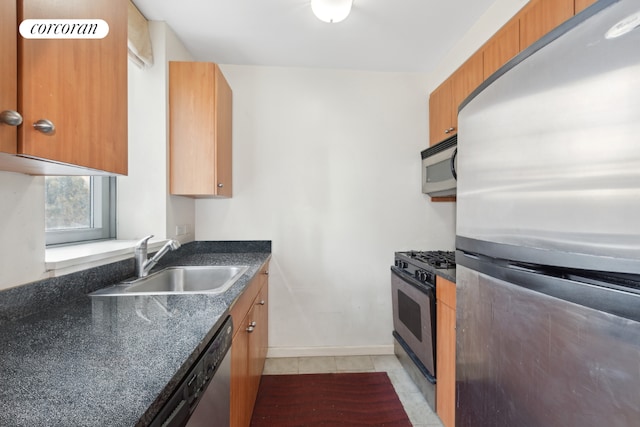 kitchen with stainless steel appliances, sink, and light tile patterned floors