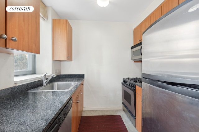 kitchen featuring a sink, light tile patterned floors, brown cabinetry, and stainless steel appliances