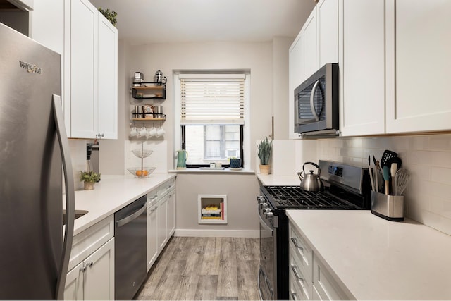 315 E 77th St Unit 1E, New York City, NY 10075 - kitchen with stainless steel appliances, decorative backsplash, light wood-type flooring, and white cabinetry