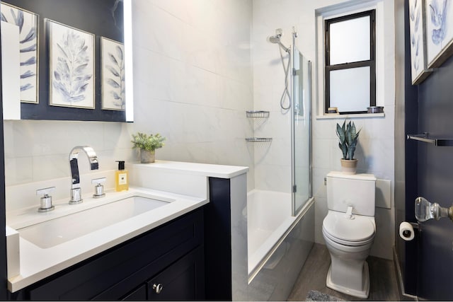 315 E 77th St Unit 1E, New York City, NY 10075 - full bathroom with tile walls, toilet, vanity, and combined bath / shower with glass door