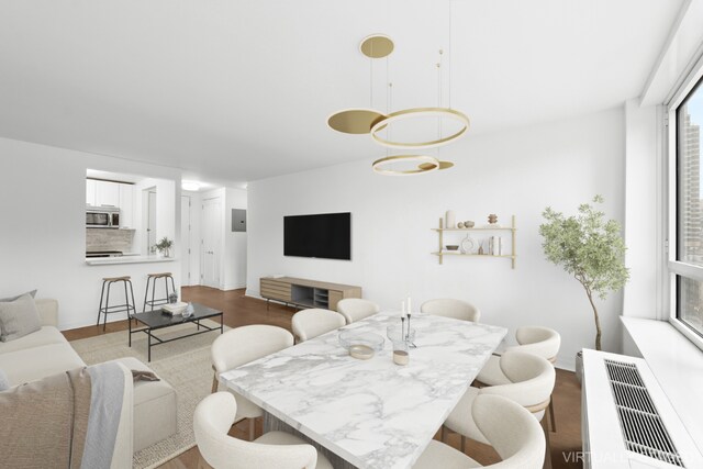 dining area with light hardwood / wood-style floors and radiator heating unit