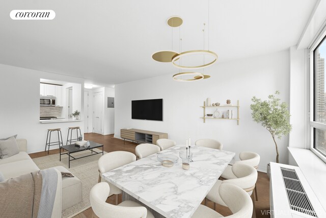 dining space with light hardwood / wood-style flooring and radiator heating unit