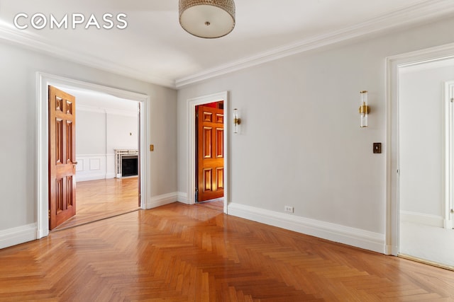 empty room featuring crown molding and baseboards