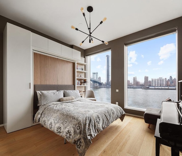 bedroom with hardwood / wood-style flooring and a water view