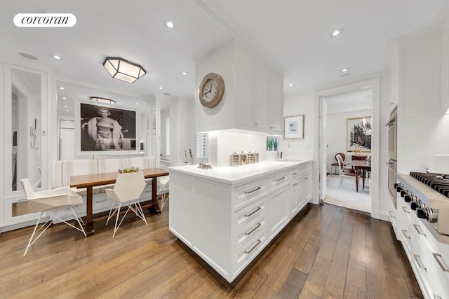 bathroom featuring hardwood / wood-style flooring, ornamental molding, sink, and breakfast area