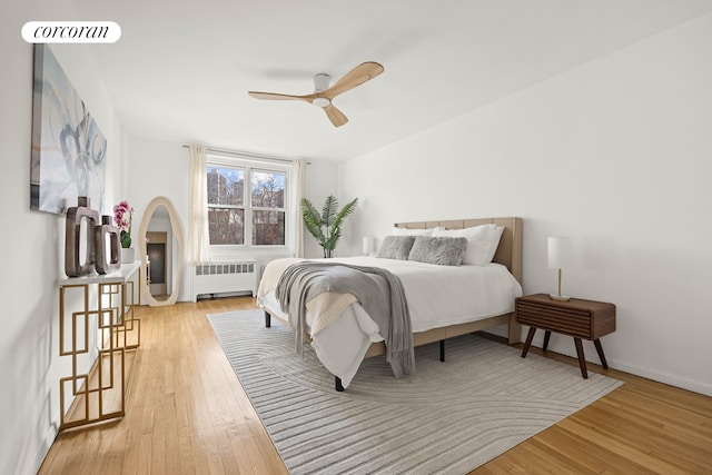 bedroom featuring light wood-type flooring, radiator, visible vents, and baseboards