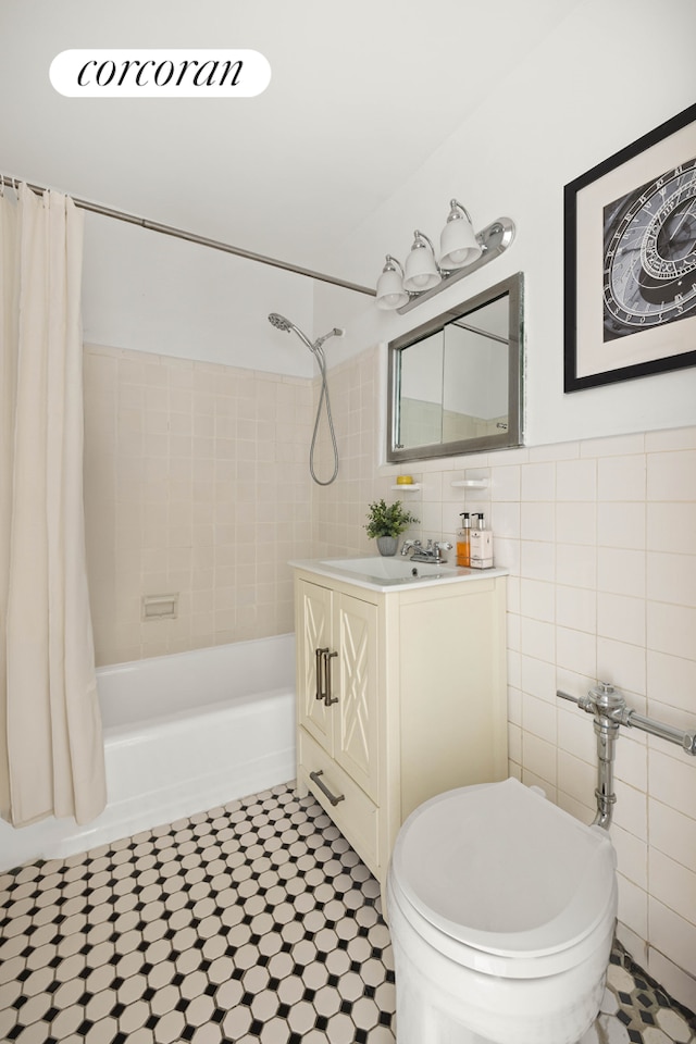 full bathroom with toilet, shower / tub combo, vanity, and tile walls