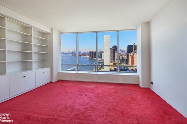 unfurnished living room featuring dark parquet floors and a water view