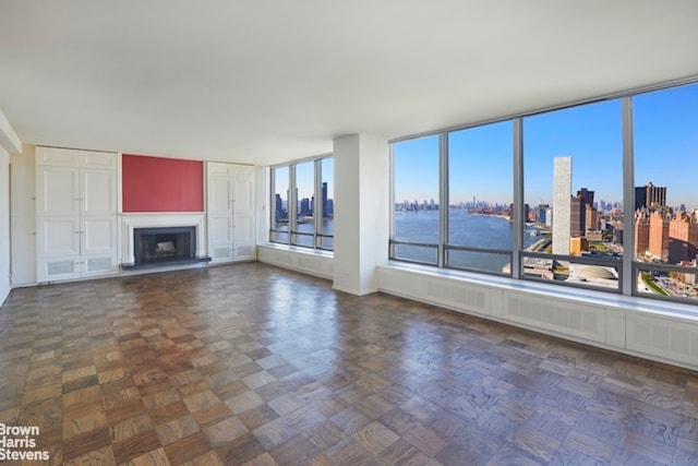 unfurnished living room featuring a view of city and a fireplace with raised hearth