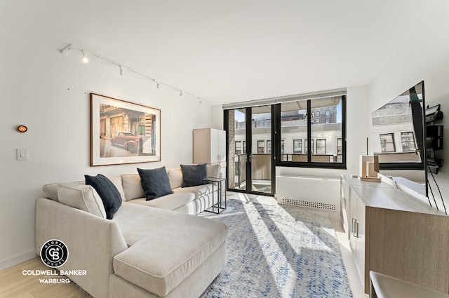 living room featuring a wall of windows and light hardwood / wood-style floors