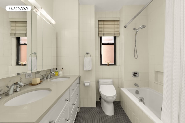 full bathroom with shower / tub combo with curtain, a sink, tile walls, and toilet