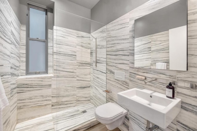 bathroom with toilet, sink, tile walls, and a tile shower