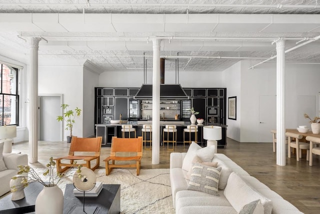 living room with hardwood / wood-style floors and decorative columns