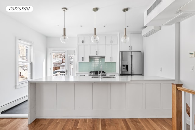 kitchen featuring baseboard heating, a wall mounted AC, visible vents, and stainless steel fridge with ice dispenser