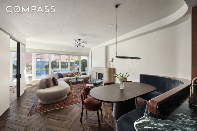 dining space featuring dark parquet flooring and a fireplace