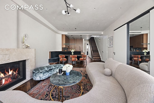 living room with a premium fireplace and a notable chandelier