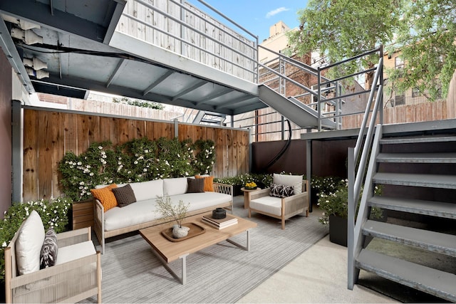 view of patio featuring stairway, an outdoor hangout area, and fence