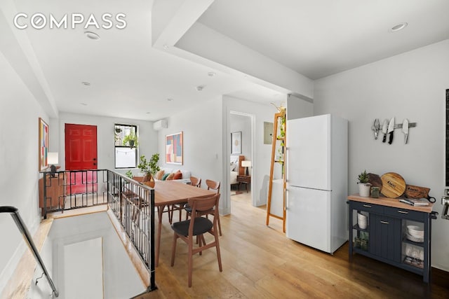 dining area featuring a wall mounted air conditioner and hardwood / wood-style floors