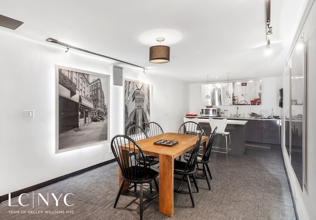 dining room featuring baseboards and track lighting