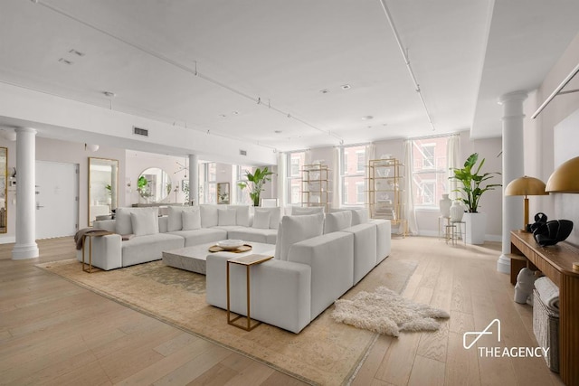 living room featuring ornate columns and light hardwood / wood-style floors