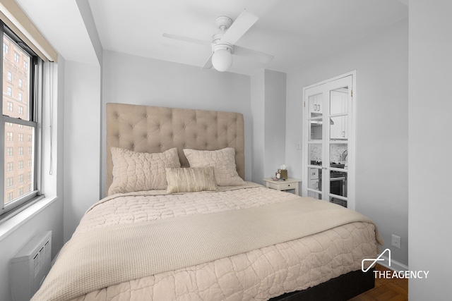 bedroom featuring ceiling fan, a wall mounted AC, and baseboards